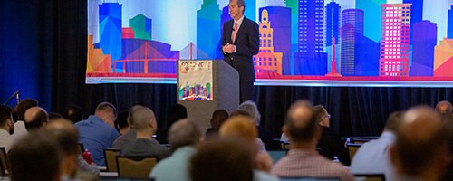 A crowded auditorium watches a presentation at a NAFEMS World Congress